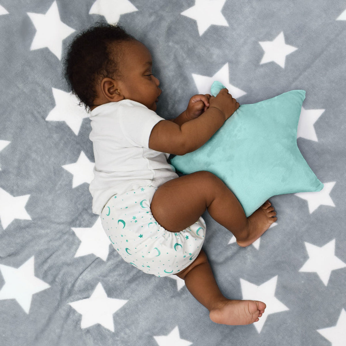 Baby liegt auf einer Sterndecke mit Bambino Mio Stoffwindel, Anwendungsbeispiel