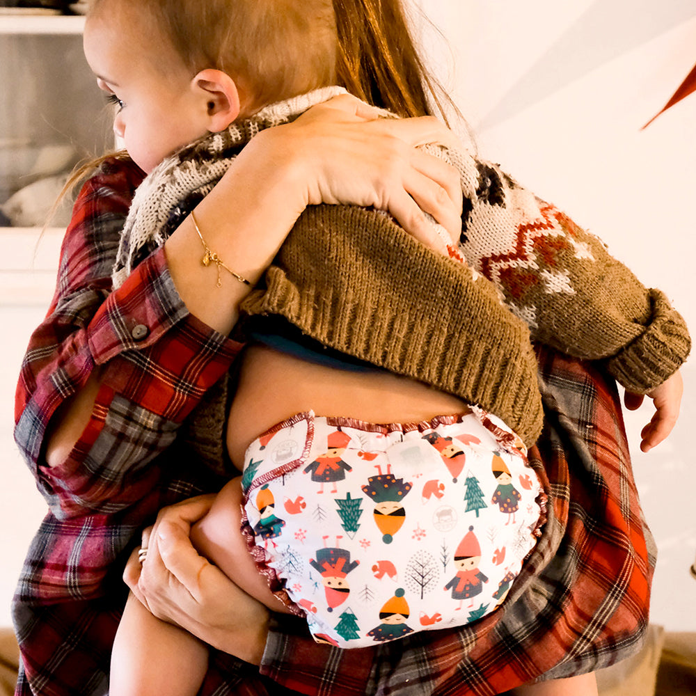 Anwendungsbeispiel: Mutter hält ihr Baby in der Culla di Teby Höschenwindel im Design Childhood