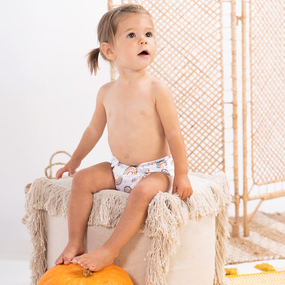Kleinkind trägt die Doodush Überhose V2.0 mit Laschen im Design Boho Rainbow
