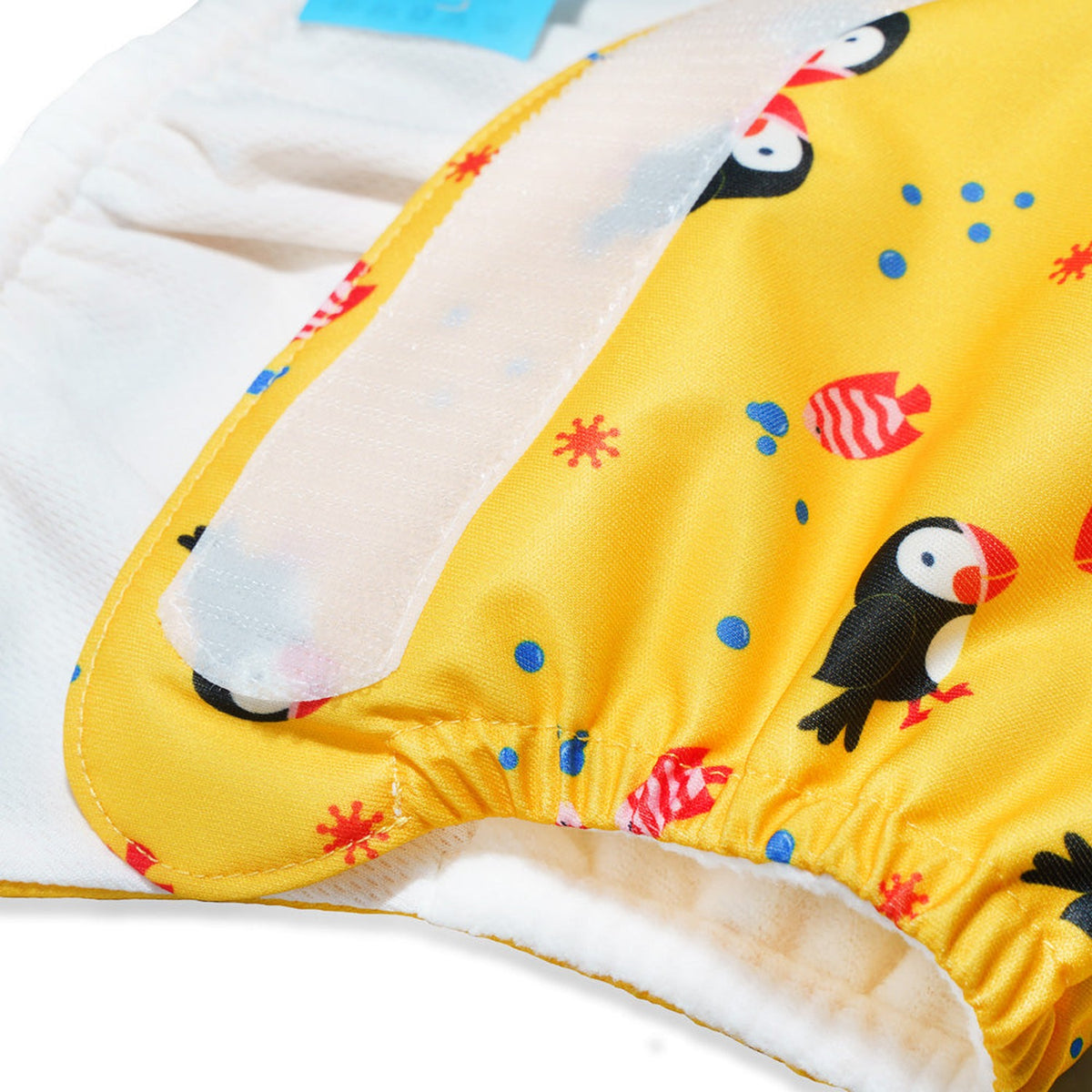 Nahaufnahme der Little Clouds SuperCloud All-in-One-Windel im Design Papageientaucher: Klettverschluss und weicher Bund an der Innenseite