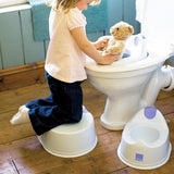 Kind auf der Toilette mit Bambino Mio MioSeat Toilettensitz, daneben ein Töpfchen