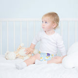 Baby sitzt im Bett in Bambino Mio MioSolo Dreamy Giraffe