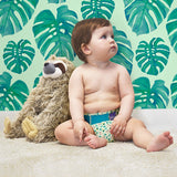 Baby mit Faultier-Kuscheltier in Bambino Mio MioSolo Swinging Sloth