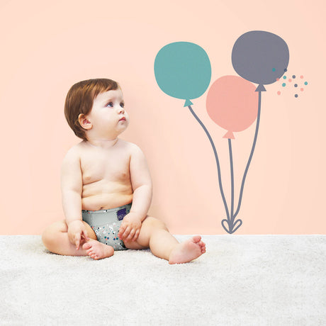 Baby sitzt vor Ballons in einer Bambino Mio MioSolo Windel