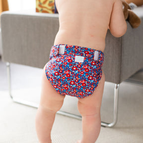 Kind trägt die Culla di Teby „Soft Touch“ Überhose und Schwimmwindel im Design Blumenwiese