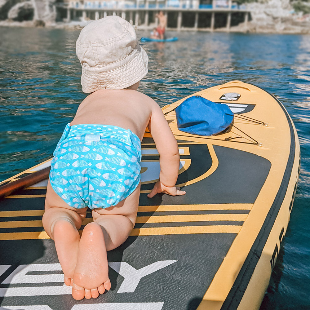 Kind trägt die Culla di Teby „Soft Touch“ Überhose und Schwimmwindel im Design Fish and Kids