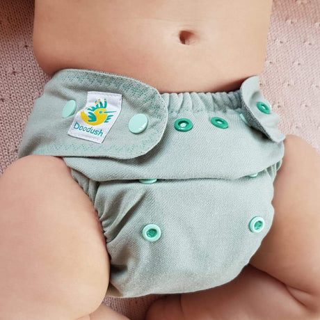 Nahaufnahme: Baby in der Doodush Wollüberhose Mint Cloud