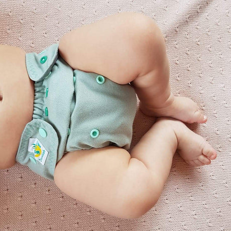 Baby trägt die Doodush Wollüberhose Mint Cloud