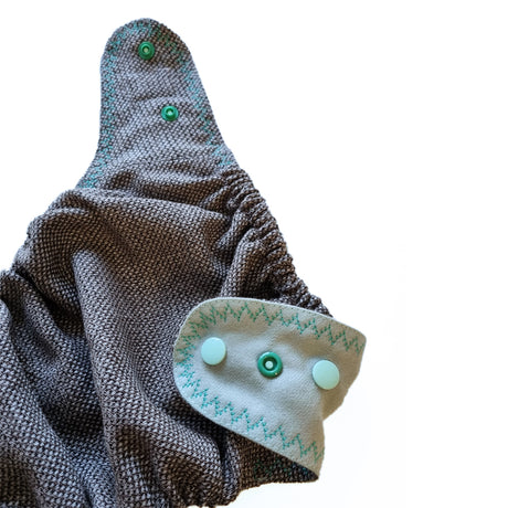 Detail der Doodush Wollüberhose Mint Cloud mit Druckknopf-Lasche