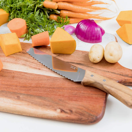 KiddiKutter KandoKutter Messer auf Holzschneidebrett mit geschnittenem Gemüse, Kartoffeln und Zwiebel