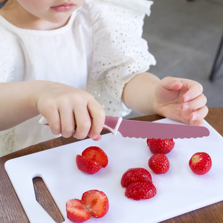 Kind schneidet Erdbeeren mit dem KiddiKutter V2.0 Kindermesser (Anwendungsbeispiel in Rosa)