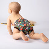 Baby krabbelt von hinten gesehen in der Petit Lulu SIO-Überhose im Design Ladybugs Fair