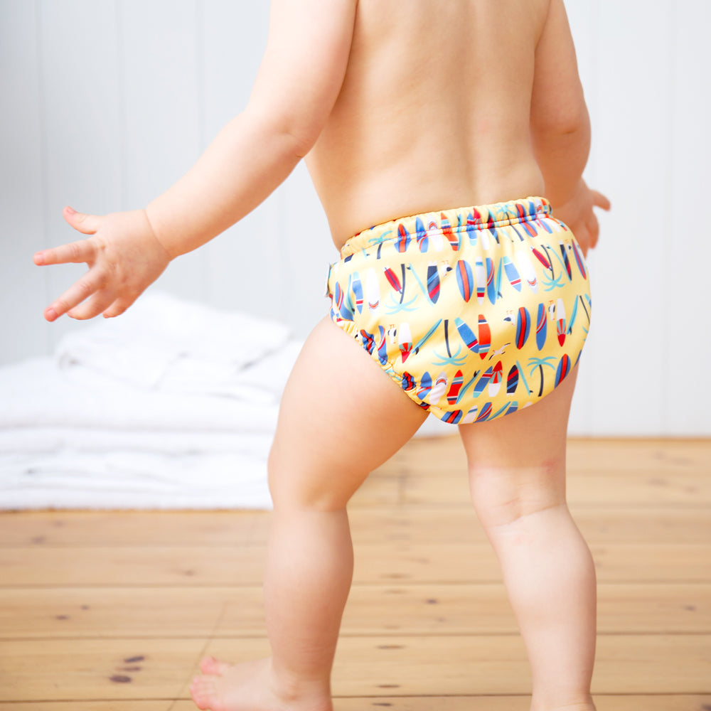 Kind trägt die TotsBots Pull-up Schwimmwindel Größe 5 (2–3 Jahre) im Design Surf’s Up