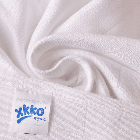 Nahaufnahme einer weißen XKKO Mullwindel aus Bio-Baumwolle mit eingenähtem Logo-Etikett