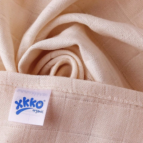 Ungebleichter XKKO Bio-Musselin in Nahaufnahme mit Logo-Etikett und Webkante
