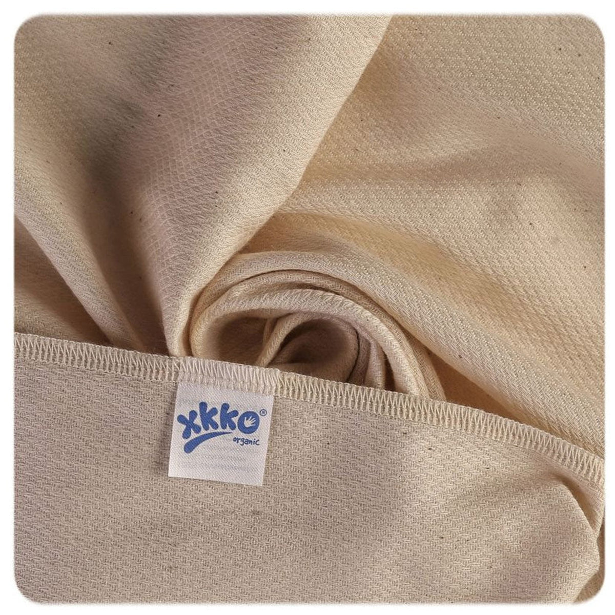 Saugfähiger XKKO Birdseye-Stoff in Natur in Nahaufnahme mit Logo-Etikett
