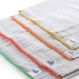 Weiße XKKO Prefolds in Nahaufnahme mit gelbem, orangem, rotem und grünem Saum